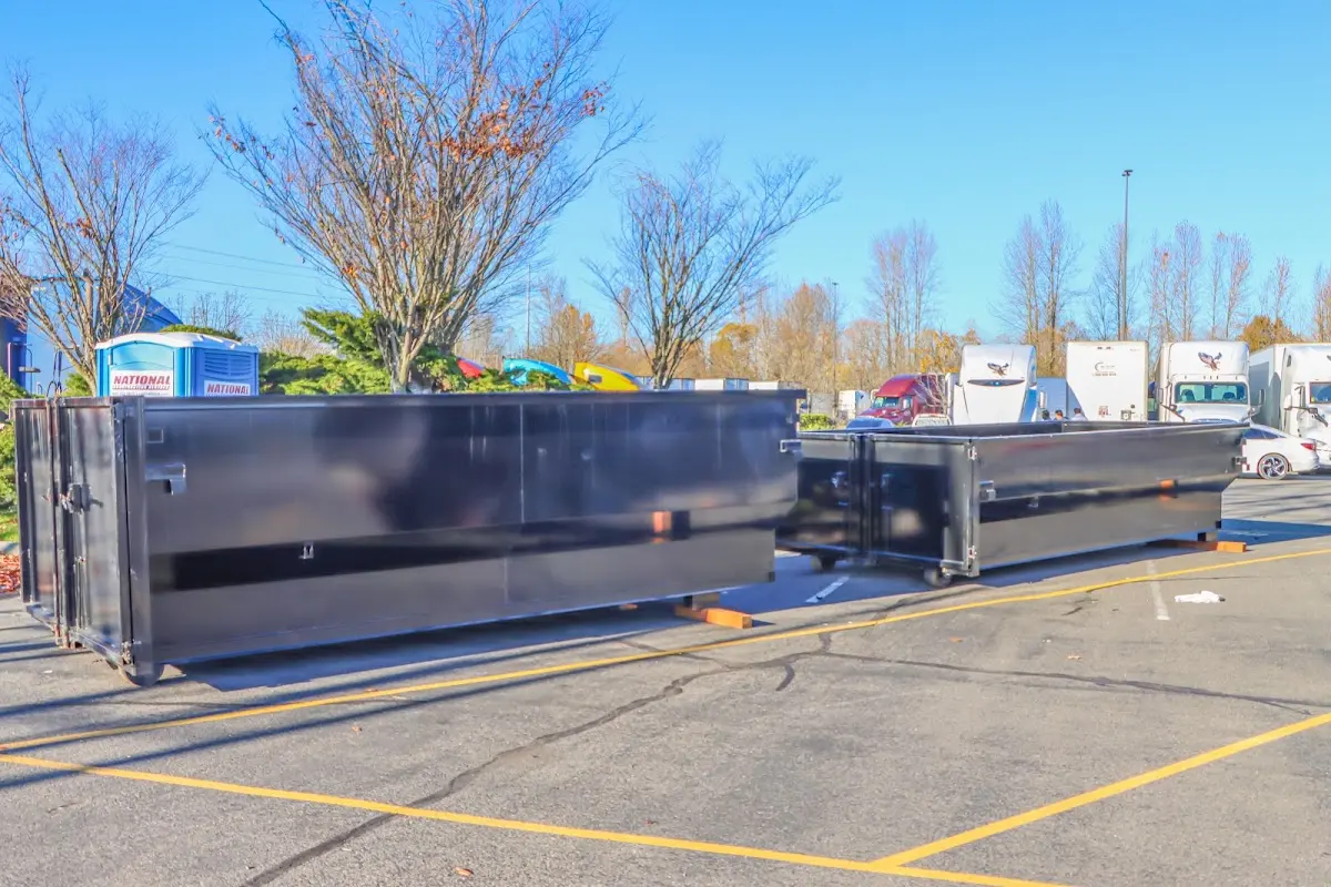 Professional dumpster rental service with roll-off container on residential driveway in Kimball